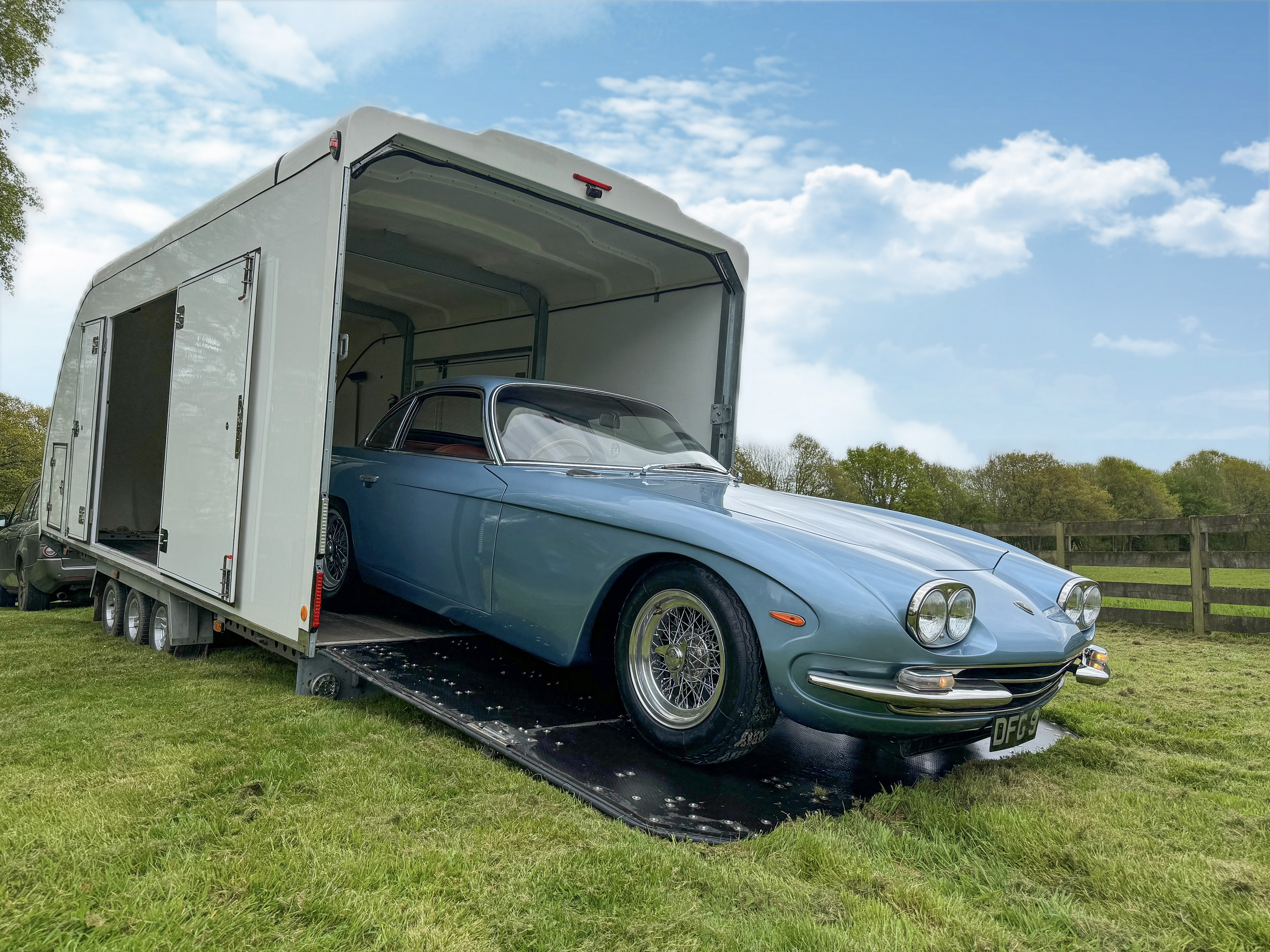 Classic car being loaded into an enclosed transport trailer
